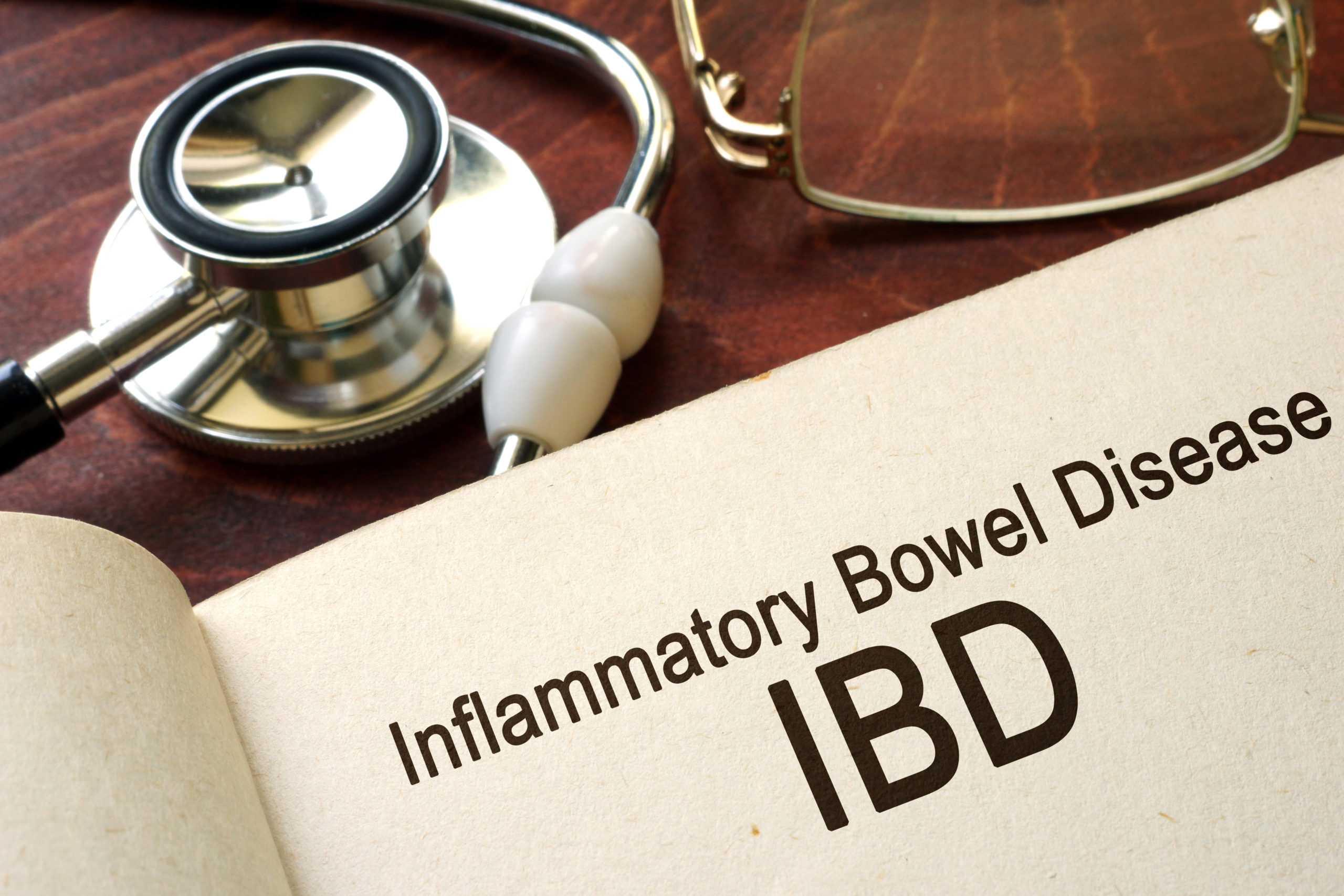 Book with words inflammatory bowel disease IBD on a table.