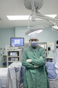 In-story individual picture: Dr. Ahmed Nasr in a CHEO operating room in scrubs.
