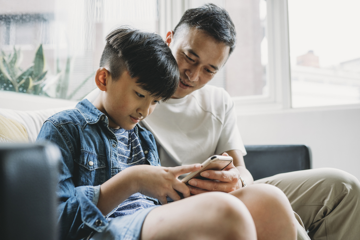 father and son using mobile phone
